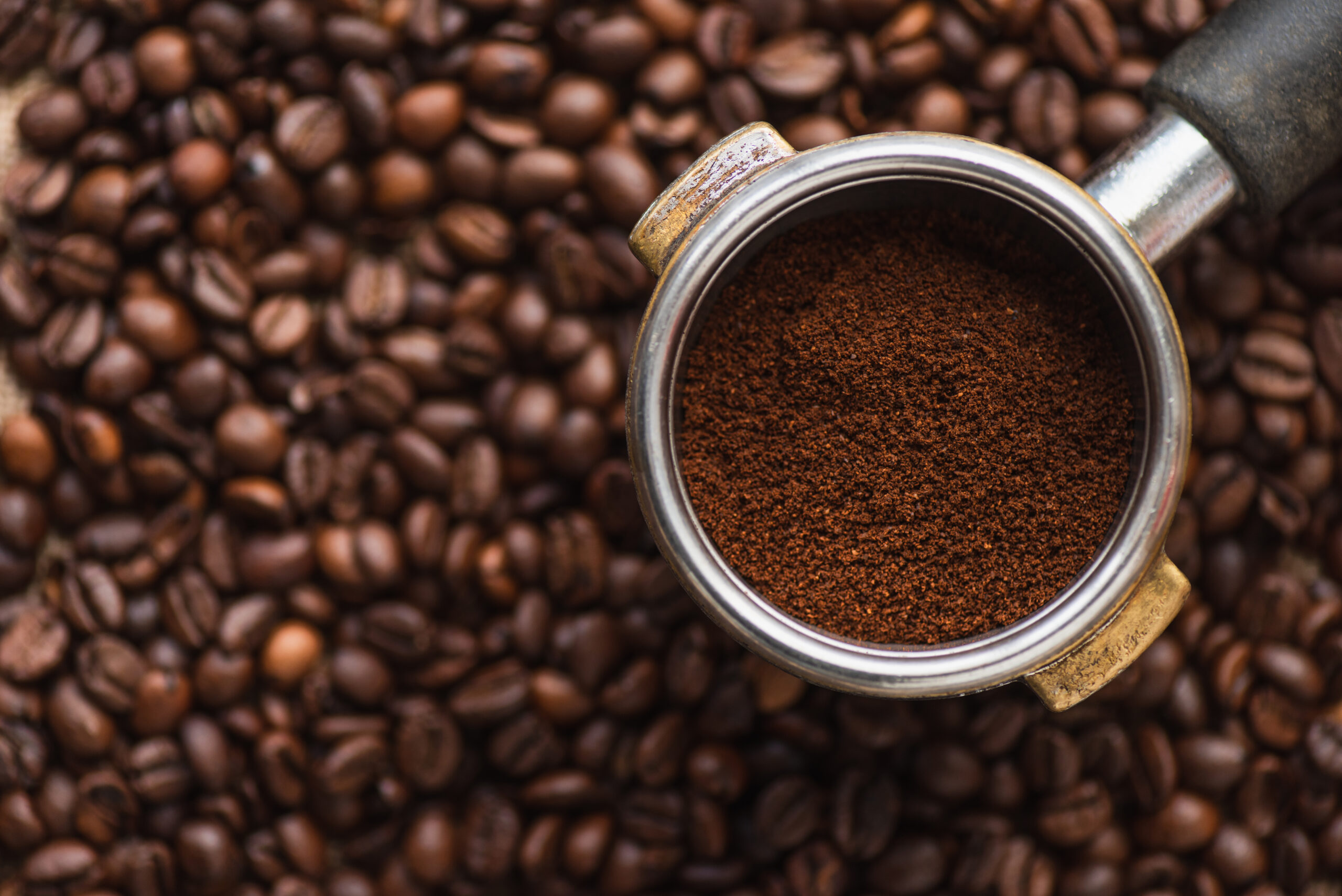 top-view-of-ground-coffee-in-portafilter-on-coffee-2023-11-27-04-50-40-utc-scaled.jpg